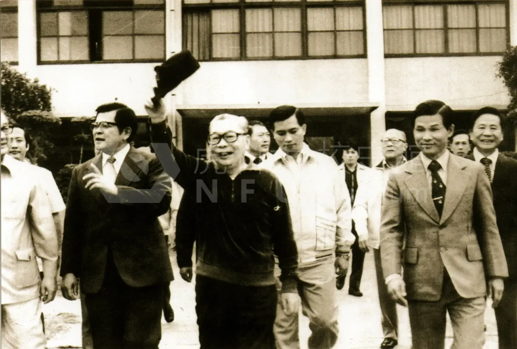 一群人正在走路，其中一個人向他人脫帽致意。