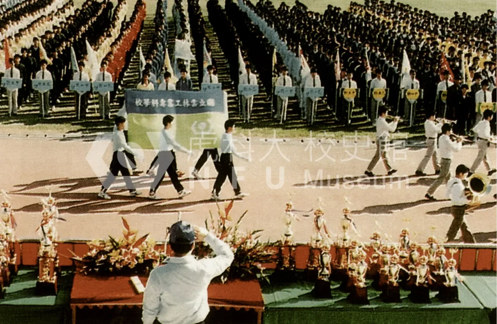 學生們在操場上列隊，前方有樂隊和旗手經過。